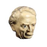 A celluloid novelty tape measure in the form of the head of Lloyd George, the tape printed in cm and