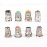 Eight continental white metal and silver thimbles with polished stone tops, mostly with decorative