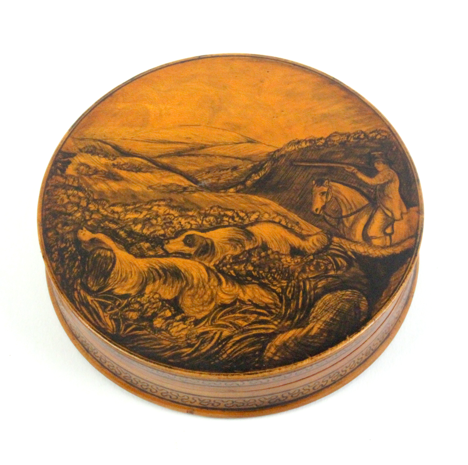 Mauchline ware - a good circular table snuff box the lid in pen work with a huntsman on horse with