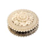 An ivory disc form pin cushion, circa 1830, each side pierced and carved with flowers and leaves