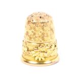 An attractive heavy 9ct gold thimble the frieze with a band of raised flowers on a ribbed ground, by