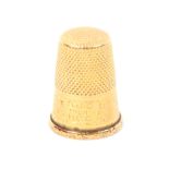 A gold thimble, probably French, the frieze initialled and with line and dot decoration