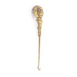 A brass button hook cast as a Nubian head with polished agate ball 'hair', one glass eye lacking,