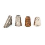 Four thimbles comprising a tall English silver example the engraved frieze inscribed 'Forget Me