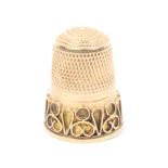A Victorian gold thimble with Etruscan style wire work overlay frieze
