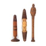 Three wooden needle cases comprising a tall standing example terminating in a carved male figure,