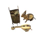 Three gilt brass novelty tape measures comprising a scarce example as a rabbit seated on a garden