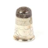 An early 19th Century steel top English silver thimble, engraved frieze with vacant cartouche