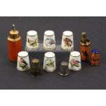 Nine thimbles and thimble compendiums comprising a thimble compendium in enamel with silhouette