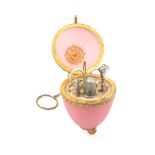 A French pink frosted glass and gilt mounted etui of egg form for a child, ring and chain