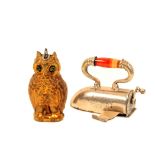 Two metal novelty tape measures comprising a gilt brass owl with glass eyes and a white metal iron