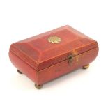 A Regency red leather sewing box for a child, of sarcophogal form on gilt ball feet and floral lid