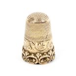 A 19th Century gold thimble the engraved frieze over a undulating 'C' scroll rim