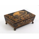 A pretty Regency penwork box of sarcophagal form the sides with trailing floral branches, the lid