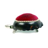 A tortoiseshell and silver mounted pin cushion in the form of a tortoise, the shell body with red