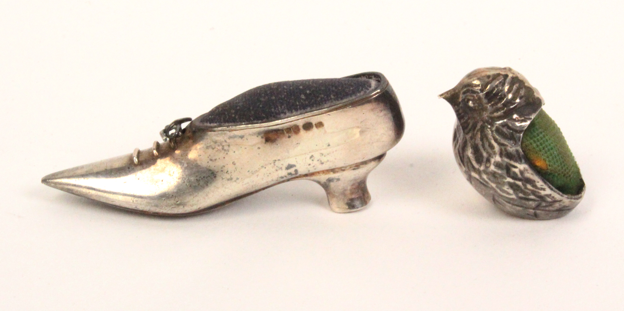 Two silver pin cushions comprising a chick, import marks, 2.5cm, and a lady's shoe with wire lace,