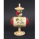 A painted bone standing pin cushion/tape measure the pedestal base supporting a barrel form double