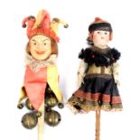 Two dolls on handles comprising a jester, composition painted head the handle with brass bells,