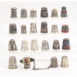Twenty one foreign white metal thimbles some with enamel decoration mostly of a souvenir nature (