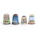Four enamel decorated thimbles comprising a white metal example with green ground floral border,