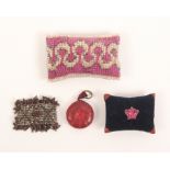 Four pin cushions comprising a coronation cushion in grained maroon paper with blue pad centered