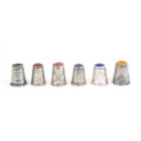 Six continental white metal early 20th Century thimbles all with coloured stone tops, three with