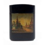 A Russian lacquer box of oval section, painted with a rectangular panel of a church and buildings