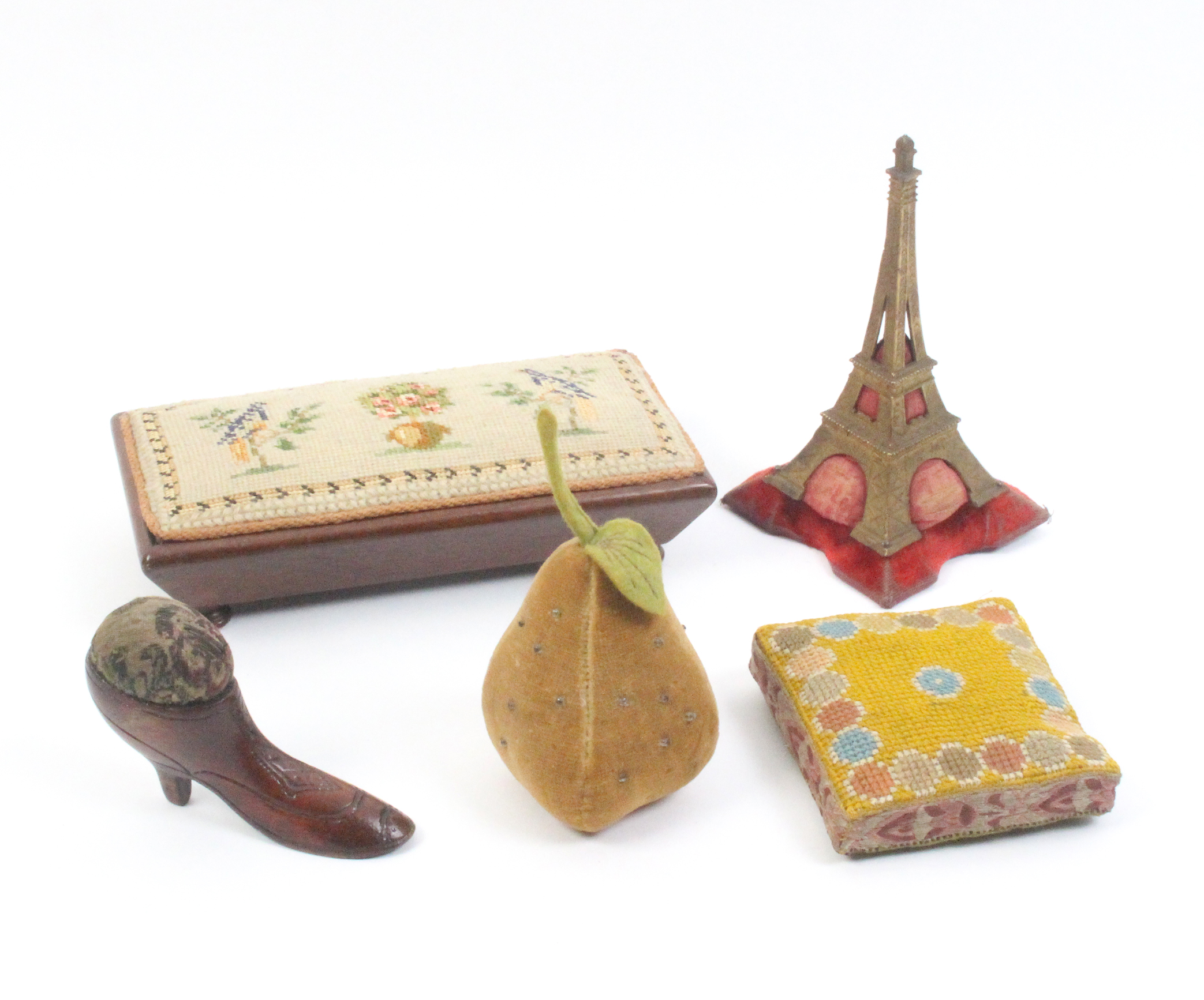 Five larger format pin cushions comprising a cast metal example in the form of The Eiffel Tower,