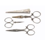 Three pairs of steel scissors and a silver sheath all with decorative arms and loops, largest 9cm,