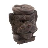 A 19th Century German carved wood tobacco box in the form of a dog's head wearing a smoking cap,