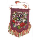 A Victorian wool and beadwork banner screen of floral design within a purple ground and cord border,