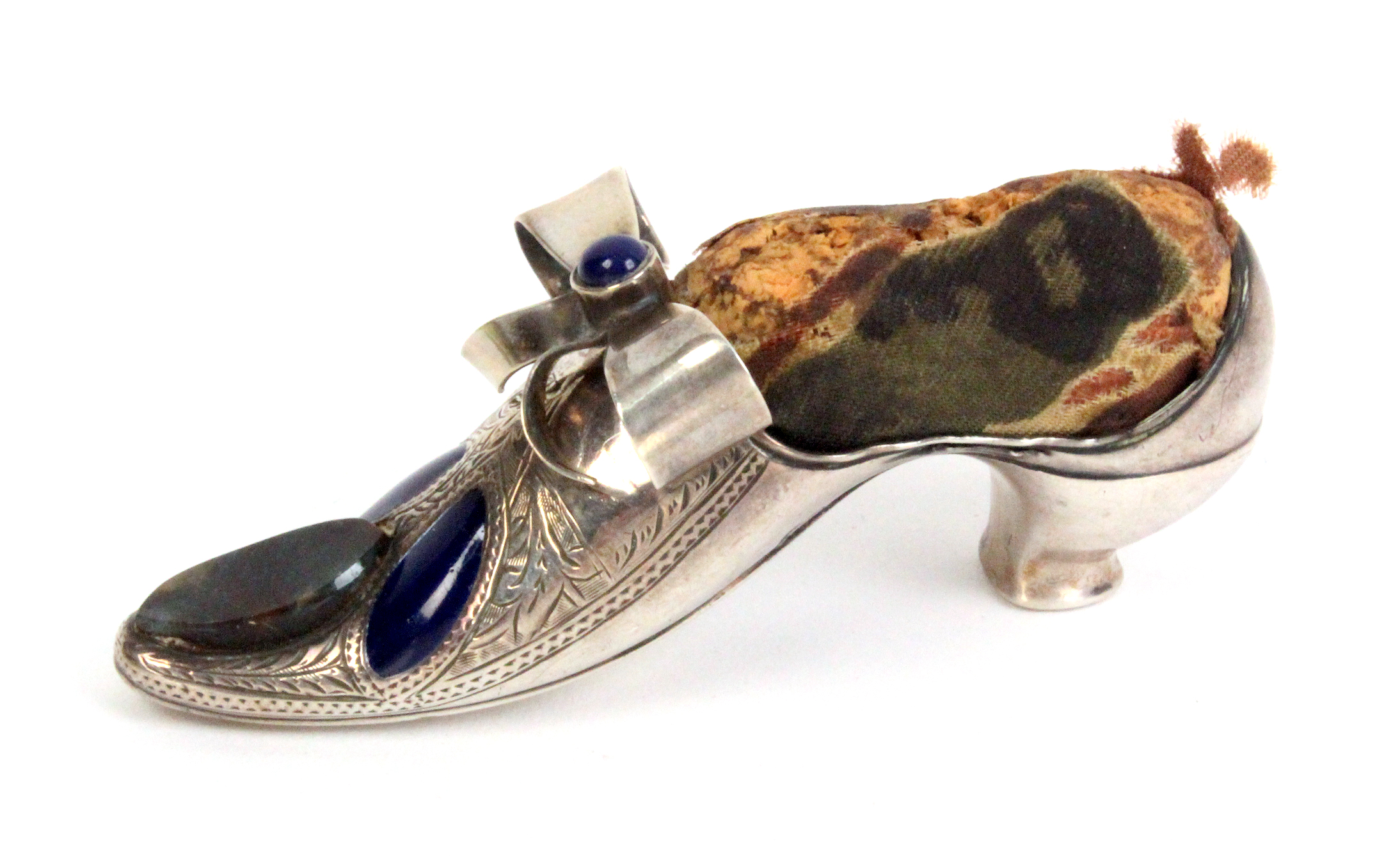 A silver and embellished pin cushion in the form of a lady's shoe the point with oval agate and