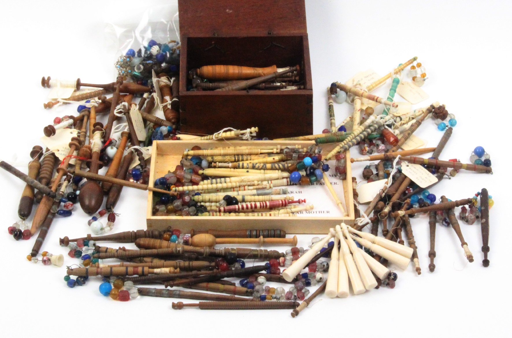 A collection of lace bobbins comprising wooden examples together with a mahogany bobbin box and a