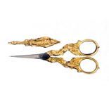 A pair of gold mounted scissors with sheath, circa 1850, the tapering steel blades with scroll,