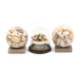 Three Victorian shell work ornaments comprising a pair of glass domes filled with sea shells on