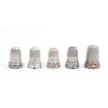 Five early 20th Century silver and white metal thimbles all with decorative friezes all but one with