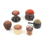 Six pin cushions comprising an ebony saucepan, 6.5cm, a vegetable ivory basket form example, a