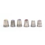 Six continental white metal early 20th Century thimbles all with coloured stone tops two with