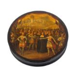 A Stobwasser circular papier mache snuff box, the lid with a scene of a woman dressed in black