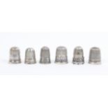 Six white metal and silver thimbles with inscribed friezes comprising four English examples -