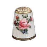 A 20th Century silver gilt and enamel thimble, the ribbed ivory enamel ground decorated with roses