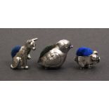 Three pin cushions comprising a silver example as a chick, Birmingham, 1926, by Adie and Lovekin