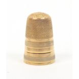 A gold thimble with two frosted bands divided by ring turned bands