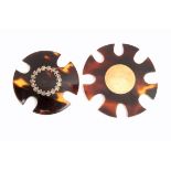 Two tortoiseshell silk winders both of circular form one inset with a circular gold disc, 4.4cm, the