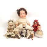 A group of dolls comprising a porcelain headed doll, open mouth, stamped 'Heubach-Koppelsdorf/320-0/