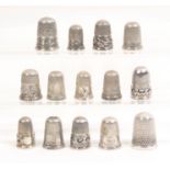 Fifteen English silver thimbles mostly with decorative border (15)