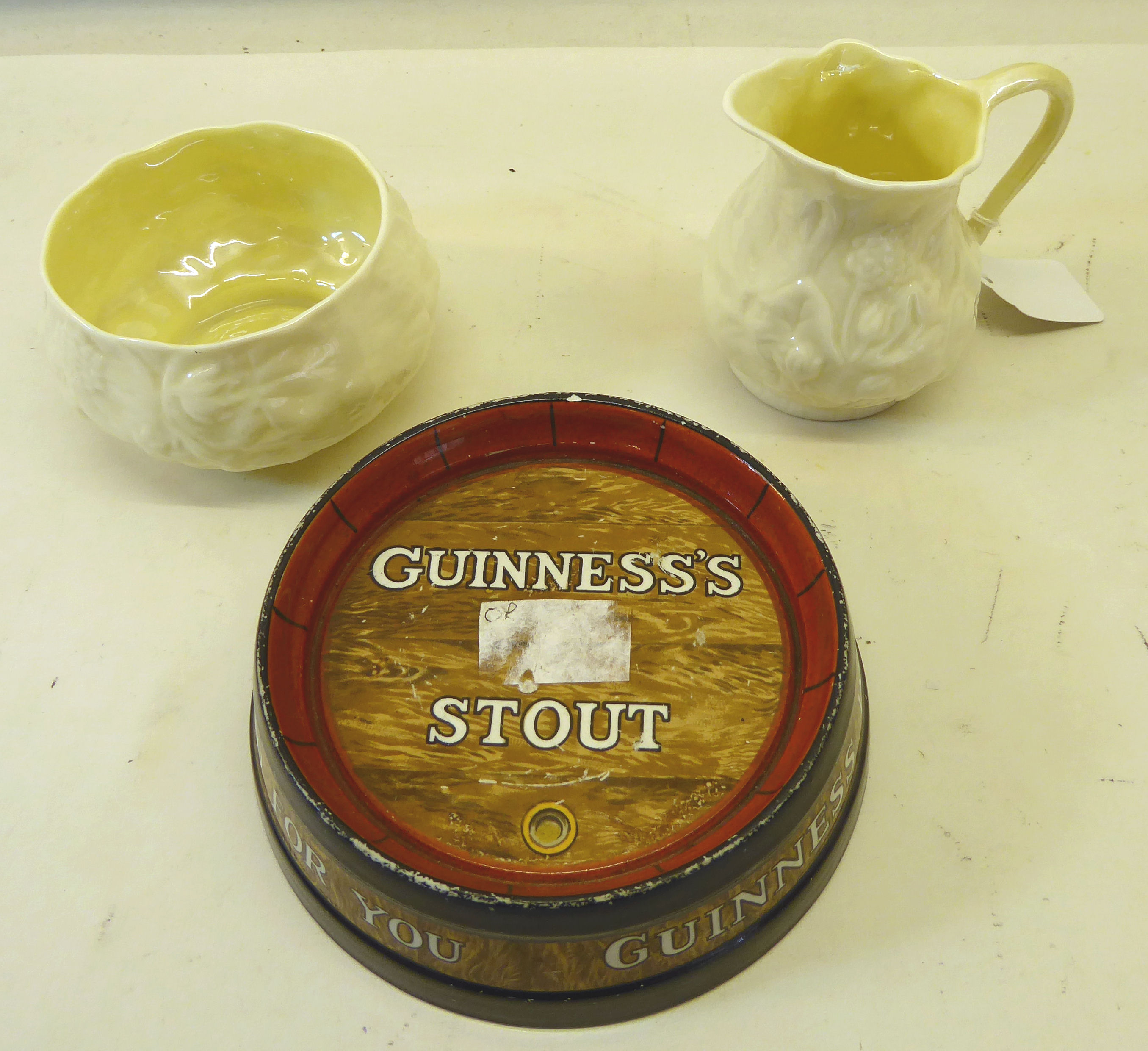 A Guinness Stout barrel top Ashtray by Minton and Belleek moulded cream jug and sugar bowl, green