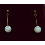 A pair of 9ct. gold pendant Earrings each set with a single opal.