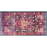 A Hamadan Rug with a centre medallion surrounded by stylised animals and flowers on a brown field