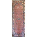 A central Asian Rug of geometric and floral design in blue, on a pink field and bordered, 9' 2" (